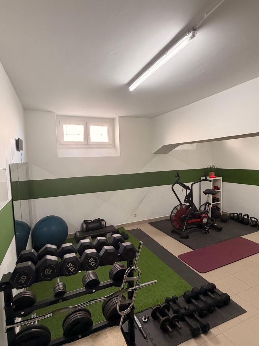 Área de treino com halteres e equipamentos